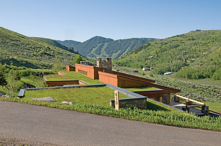 This home mimics its surroundings with native sod roofing and roof pitches that align with the home site’s topography.