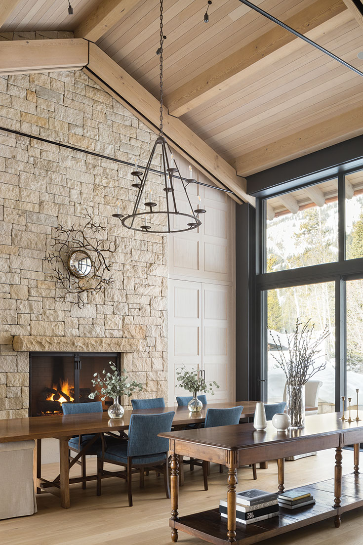 A limestone fireplace allows the natural feel of the stone to show through, with a presentation that is raw beauty. Paired with the clean lines of the expansive windows, the elegant balance in design is a striking presentation.