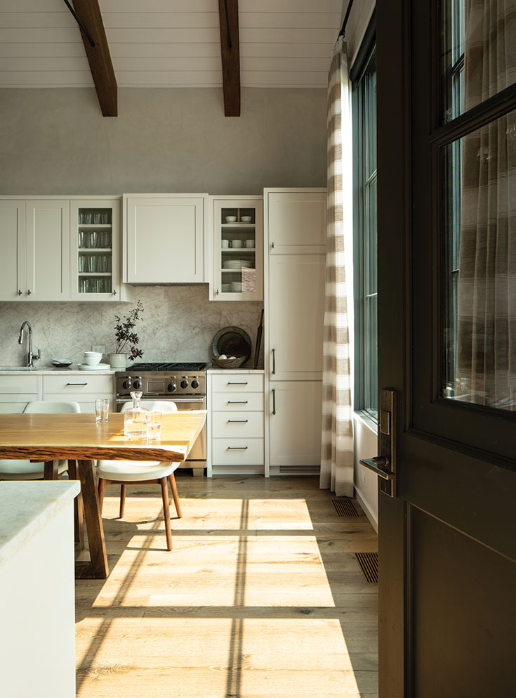 A masterpiece of quiet functionality, the kitchen hides its manifold accoutrements, including a coffee station and washer/dryer, behind custom cabinetry.