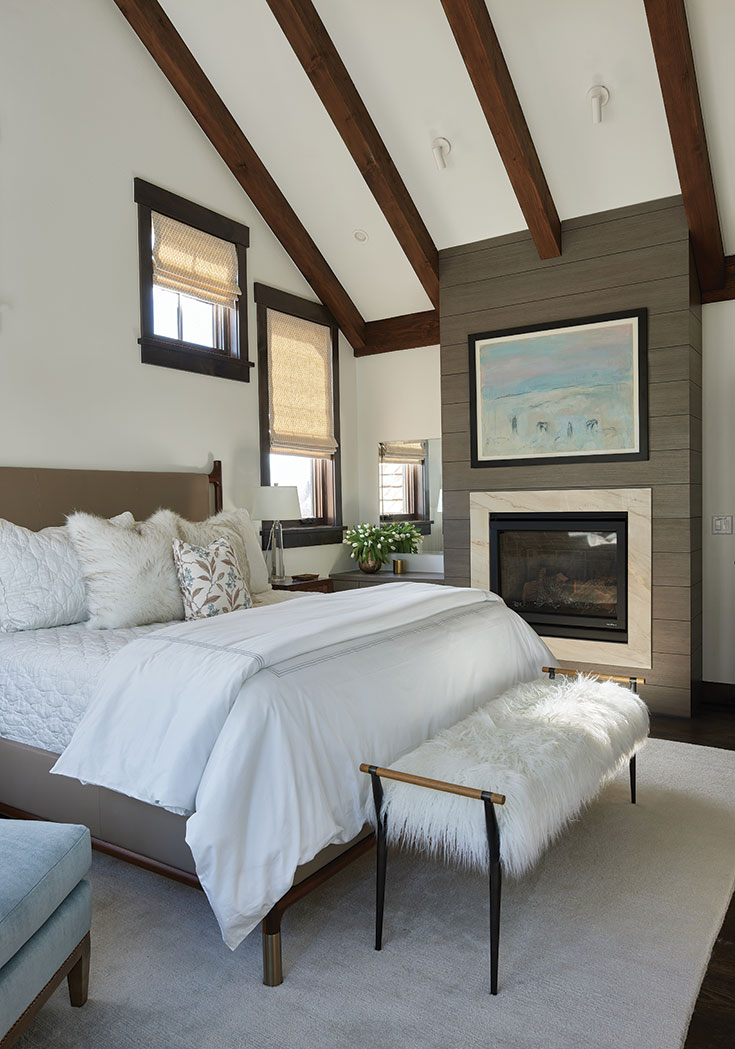 With its custom fireplace and plush seating, the light and airy primary bedroom serves as a sanctuary for rest and relaxation.