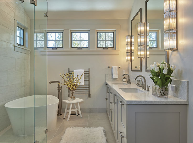 The primary bathroom evokes a spa with its soaking tub, refreshing neutrals and marble accent wall.